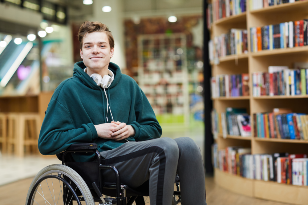 Young man in wheelchair disabled visiting library disability inclusion Fort Wayne Recovery
